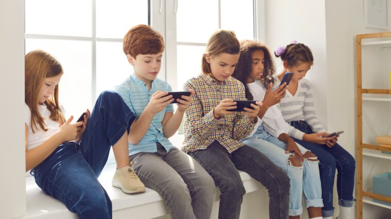 Mehrere Kinder schauen auf ihre Smartphones