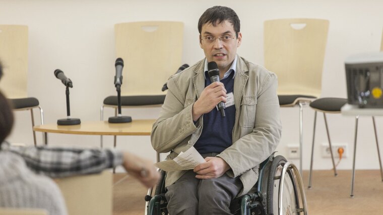 Person in wheelchair speaks infront of audience