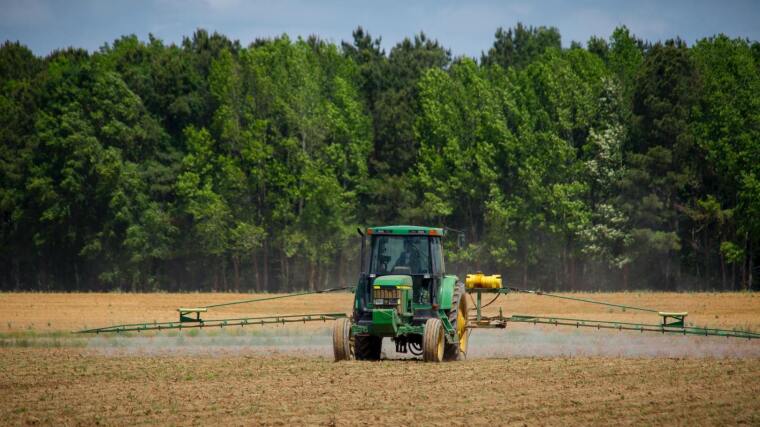 Trator spreading pesticides on a field